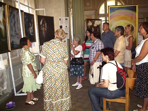 圖：烏克蘭哈爾科夫市的真善忍美展上，觀眾欣賞畫作，聆聽導覽。
