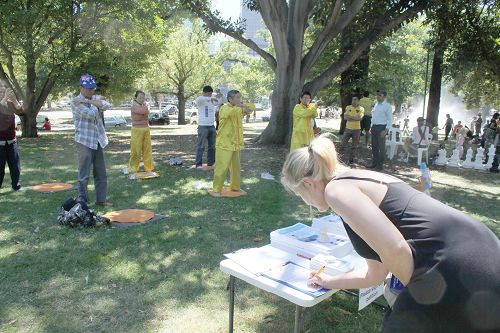 圖4-6：在遊園會上，法輪功學員設立了攤位，展示功法，並徵集簽名呼籲制止中共活摘法輪功學員人體器官的惡行。很多民眾簽名支持。