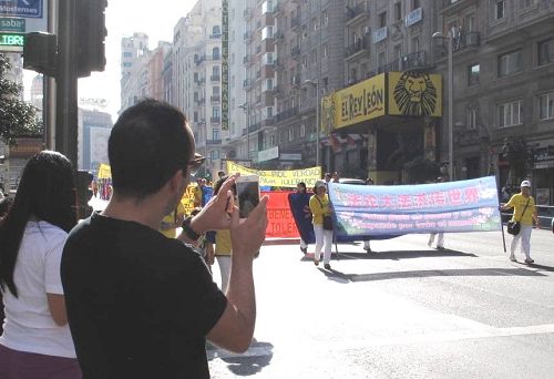 圖2：華人在馬德裏街頭觀看和拍攝歐洲法輪功學員盛大的遊行隊伍