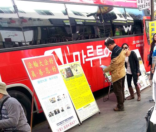 在韓國首爾景點，旅遊團的巴士旁的真相展板