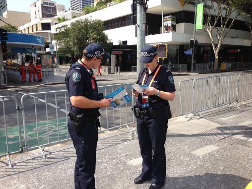 圖3：布里斯本二十國集團峰會（G20）峰會期間，澳洲警察在閱讀法輪功真相資料。