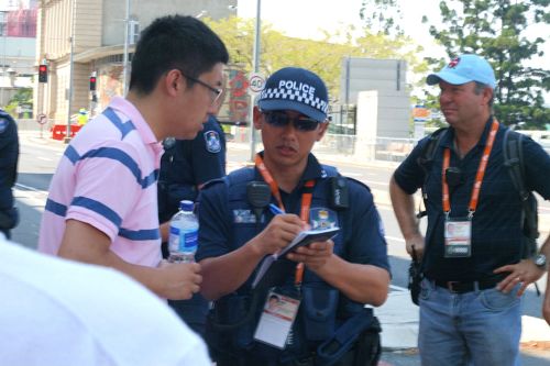 圖5：中共派來干擾法輪功學員拉橫幅的中國留學生們一一被澳洲警察要求登記護照內容，圖為組織學生來的負責人之一正在被登記。