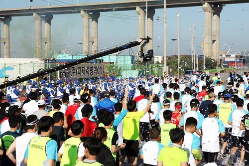 在「二零一四平澤港馬拉松大會」上，在馬拉松起跑線上，天國樂團演奏雄壯樂曲。