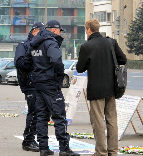 圖5：華沙中使館門前，法輪功學員為執勤警察講真相
