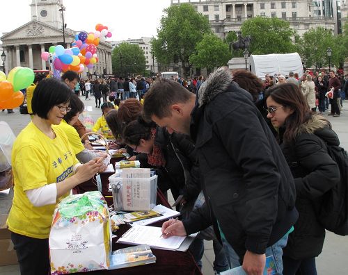 人們在反對中共活摘法輪功學員器官的徵簽表上簽字