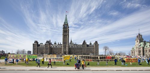 二零一四年五月七日，法輪功修煉者在加拿大首都國會山前，慶祝法輪大法洪傳世界二十二週年。