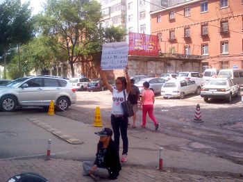張海霞的女兒和近八十歲的母親在香坊分局門前舉牌抗議