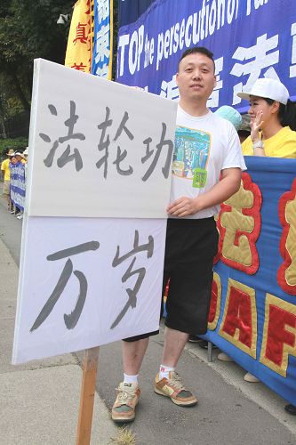 圖3：溫哥華大陸移民王先生手舉「法輪功萬歲」的標語牌自發加入集會