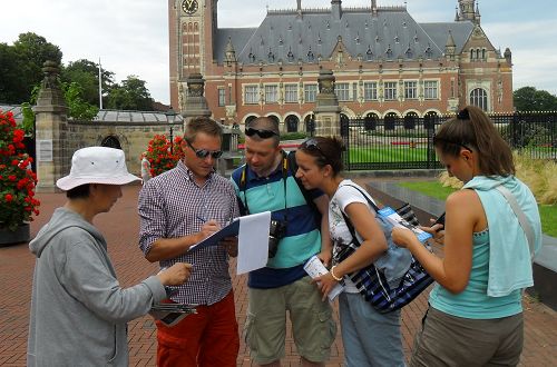 法輪功學員在海牙國際法庭門前廣場向遊客講真相