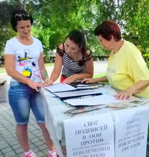 克里米亞自治共和國的法輪功學員在賽瓦斯堡市中心公園，舉行講真相、反迫害徵簽活動。民眾在了解真相後，紛紛簽名反對中共活摘暴行。