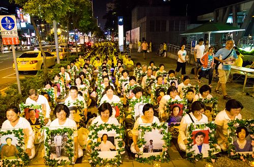 台灣高雄法輪功學員在人潮密集、陸客喜愛的高雄巨蛋、瑞豐觀光夜市和明誠公園間舉辦「七•二零燭光夜悼會」