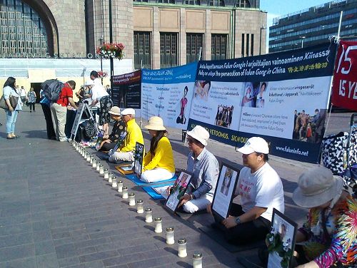 圖1：法輪功學員在赫爾辛基火車站廣場舉辦燭光悼念活動