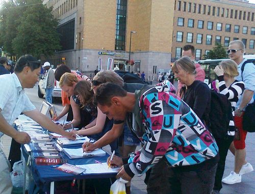 圖2-3：赫爾辛基火車站廣場上，路人排隊簽名支持法輪功反迫害