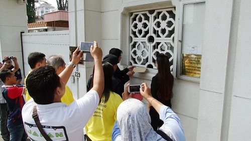 法輪功學員遞交抗議信於中共駐馬大使館，引起了許多警官的關注。