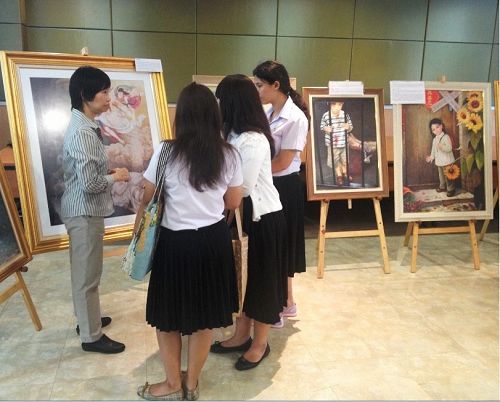 法輪功學員向前來參觀的大學生介紹美展作品。