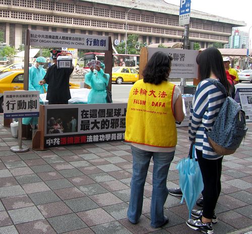 圖1：台北法輪功學員在台北車站商圈以模擬演示行動劇，揭露中共暴行