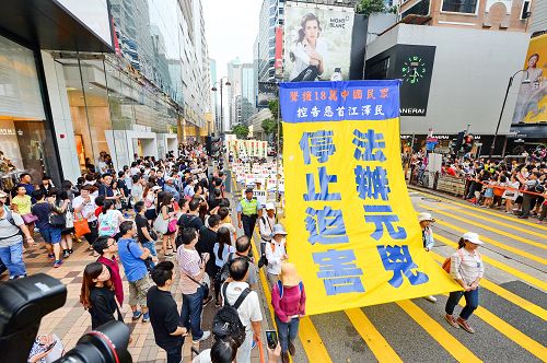 圖：十月一日，香港法輪功學員舉行「法辦元凶、停止迫害」的集會遊行，途中許多大陸遊客被遊行的場面震撼。