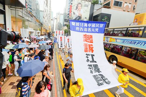 圖：許多大陸遊客被遊行的巨大橫幅標語」控訴江澤民」所震撼。