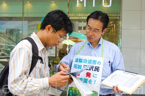 圖：日本民眾在聽法輪功學員講述法輪功被迫害真相