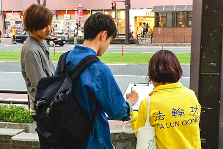 圖：日本熊本縣街頭的民眾署名聲援訴江