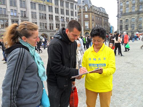 阿姆斯特丹王宮前達姆廣場上，遊客簽名支持法輪功反迫害