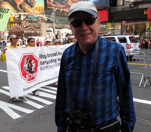 退休律師哈維•羅森加特（Harvey Rosengart）正在認真觀看法輪功學員在紐約舉行的盛大遊行