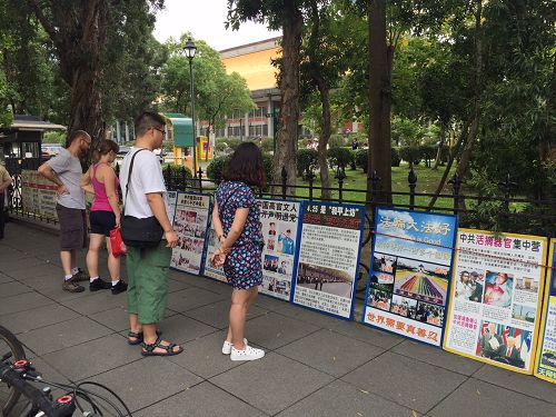 圖7-9：法輪功真相吸引民眾、尤其是中國大陸觀光客的關注，並駐足觀看真相。
