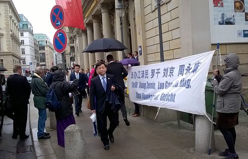 中國代表團在漢堡商會中心從和平抗議的法輪功學員面前經過
