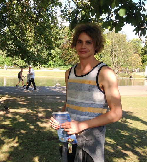 二零一五年八月二十二日，羅馬青年麥克在英國倫敦攝政公園法輪功煉功點第一次學煉法輪功，手拿意大利版的《法輪功》和法輪功學員製作的手工蓮花，高興地笑了