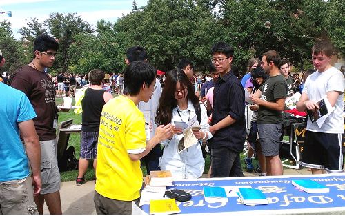 人們紛紛駐足詢問了解大法的信息，包括一些華裔和大陸來的新生