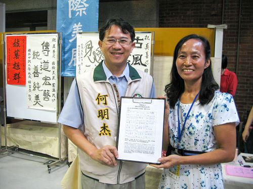 圖說2台中市議員何明杰(左)展示了他所簽署的「刑事舉報江澤民」聯署書。