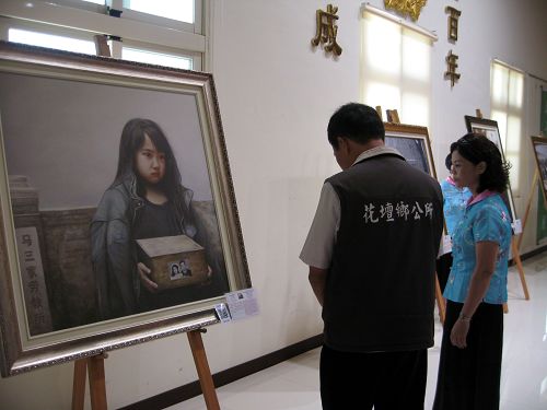 圖5：花壇鄉鄉長李成濟正在欣賞畫作《孤兒淚》。
