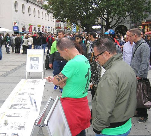 圖1-2：德國慕尼黑市中心，市民、遊客駐足閱讀法輪功真相圖板