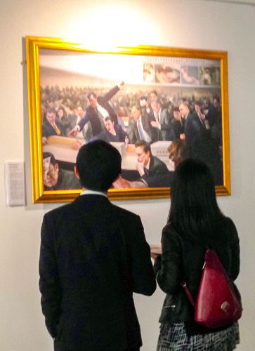圖1：二零一五年九月二日，「真善忍」美展的每幅作品在東倫敦傲案中心（The Proud Archivist）展出，兩位華人青年認真觀看畫作