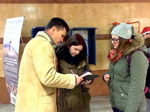 首都索菲亞的學員（左）在地鐵口講真相徵簽訴江