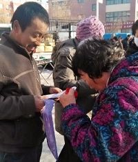 圖：民眾在舉報江澤民的舉報信上簽名、按手印。