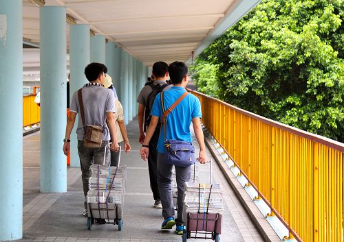 圖2：台灣青年學子們一大早就拉著各種法輪功真相材料推車搭火車到景點街頭派發並且講真相。
