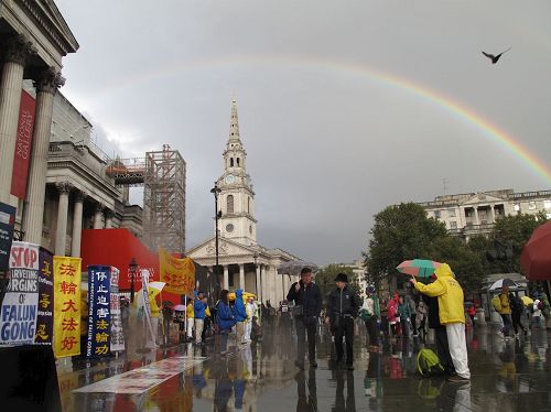 '圖16：二零一六年十月一日下午，法輪功學員在特拉法加（Trafalgar Sqare）北平台舉行集體煉功和講真相活動時，天空中出現的彩虹'