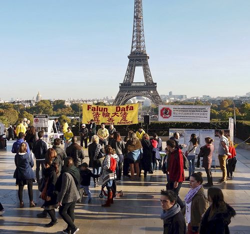 '圖1：巴黎人權廣場上遊人駐足了解法輪功真相'