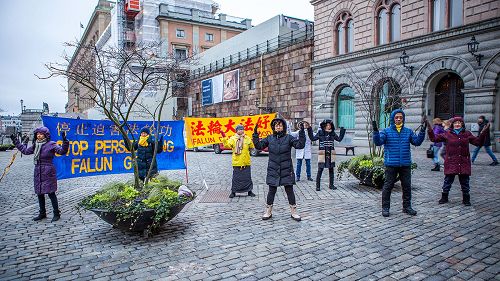 '圖1：在斯德哥爾摩最熱鬧的皇宮旁的錢幣廣場，法輪功學員向民眾講真相，揭露中共迫害。'