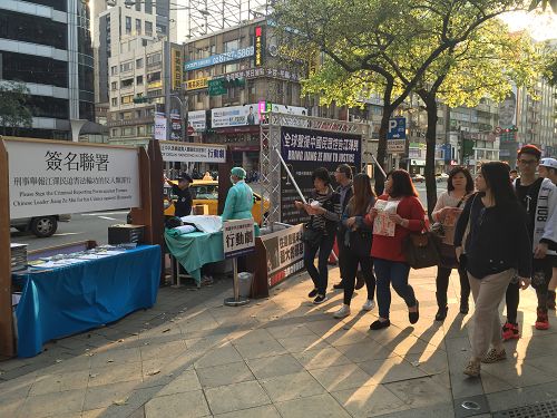 圖1-2：三月六日，台北忠孝東路商圈的街頭，法輪功學員舉辦揭露中共迫害的活動，吸引民眾關注