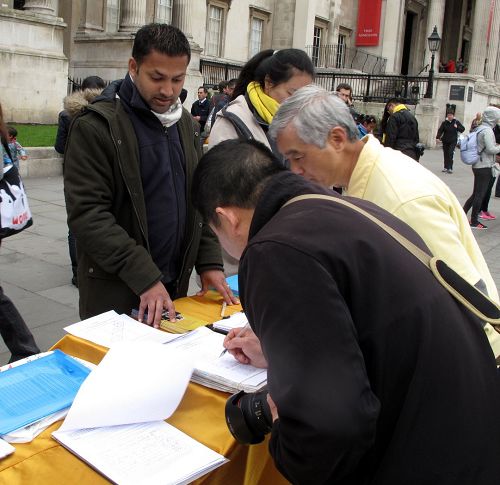 圖8：這位華人來自中國大陸，已在英國生活多年，他在反活摘、聲援起訴江澤民的文件上痛快簽自己的名字。