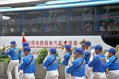 圖9：公交車上乘客為法輪功的遊行隊伍所吸引，舉起手機拍照。