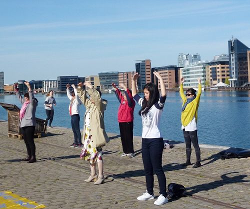 圖1-2：在「世界法輪大法日」到來之際，二零一六年五月六日，丹麥的學員來到厄勒海峽（Øresund ）旁集體煉功。