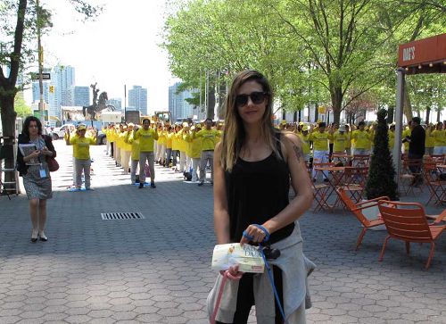 圖13：五月十二日，在紐約生活的以色列女孩羅密在達格•哈瑪紹廣場公園被法輪功學員的集體煉功場面所吸引，讚美法輪功的平和力量。