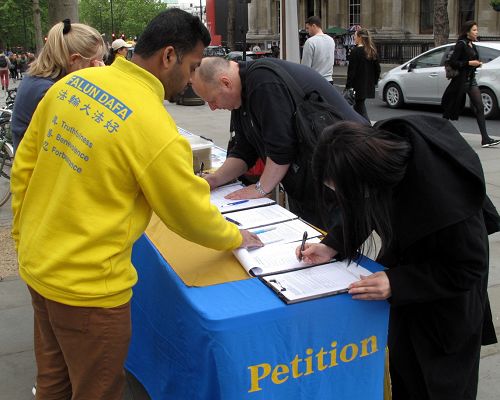 圖3：硬件工程師菲利普和女兒在倫敦聖馬丁廣場簽名支持法輪功反迫害