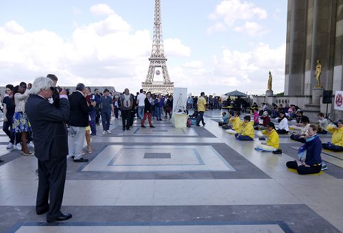 圖1-3：二零一六年六月二十六日下午，法輪功學員在巴黎艾菲爾鐵塔下的人權廣場上傳播真相。圖為法輪功學員祥和的功法場面和真相展板都吸引了中西遊客的目光。