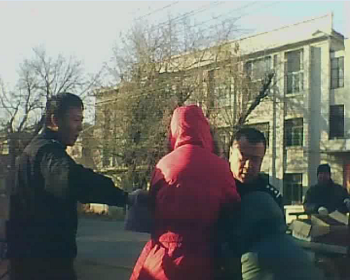 警察周佳佳（左）、張維富（右）正在搶掠祖孫二人手中的物品，老人漸漸倒地。
