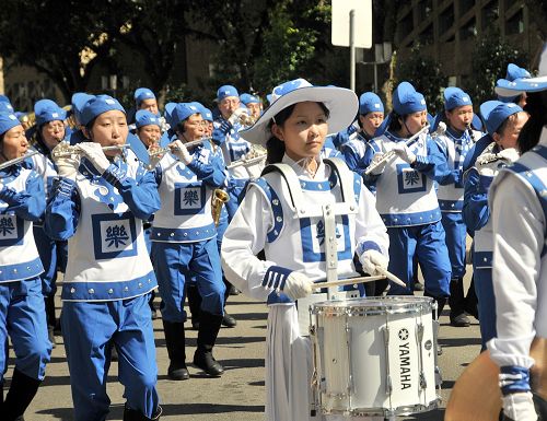 法輪功學員組成的天國樂團和腰鼓隊在遊行行進中表演。