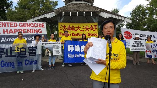 法輪功學員代表劉女士向公眾展示九千份徵集到的聲援「訴江」的簽名表。